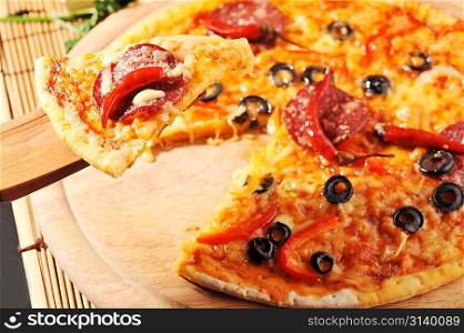 Close up of pizza with tomatoes, cheese, black olives and peppers.