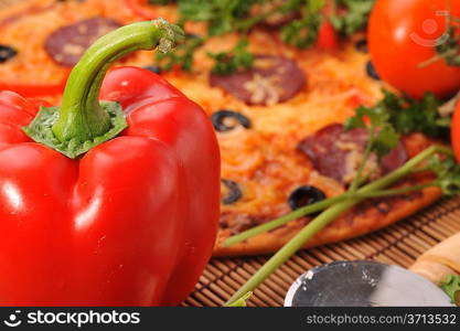 Close up of pizza with tomatoes, cheese, black olives and peppers.