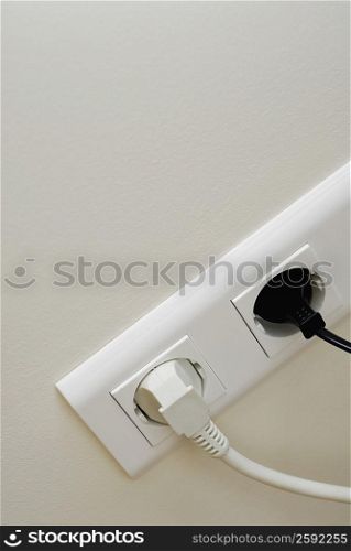 Close-up of plugs in power sockets
