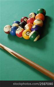 Close-up of pool balls and a pool cue on a pool table