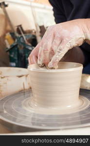 Close Up Of Potter Moulding Clay On Wheel