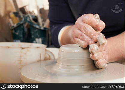 Close Up Of Potter Moulding Clay On Wheel