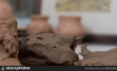 close-up of pottery clay on blurred background of pots. children’s crafts. clay art pots
