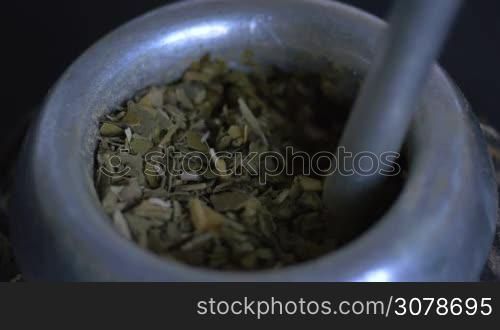 Close up of pouring hot water in mate fill with herb, a traditional beverage in Argentina