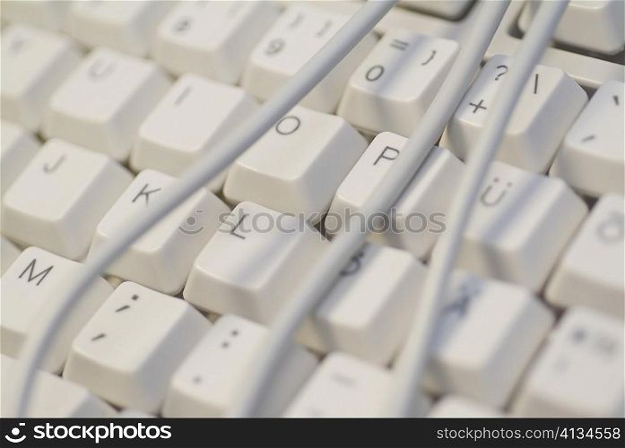 Close-up of power cables wrapped around a computer keyboard