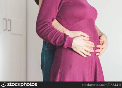 Close up of pregnant mother and father, hugging the tummy, Caucasian 