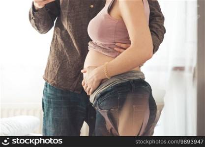 Close up of pregnant mother and father, hugging the tummy, Caucasian