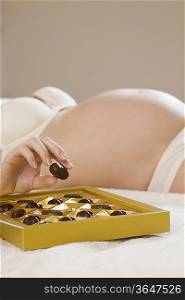 Close-up of pregnant woman&acute;s hand holding chocolate