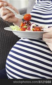 Close Up Of Pregnant Woman Eating Healthy Salad
