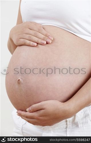 Close Up Of Pregnant Woman Holding Tummy