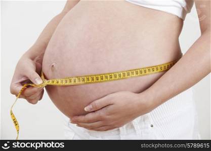 Close Up Of Pregnant Woman Measuring Waist