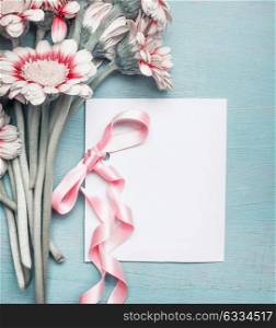 Close up of pretty flowers on turquoise blue shabby chic background and mock up of greeting card with pink ribbon for Mothers day, wedding, Birthday or happy event