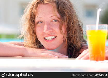 close up of pretty woman in swimming pool with cocktail