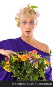 close up of pretty young blond girl in violet dress with flower and bouquet looking in camera with a surprise expression