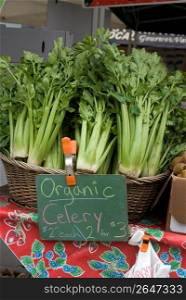 Close up of price sign on market stall selling organic celery