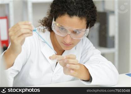 close-up of professional female scientist in protective eyeglasses