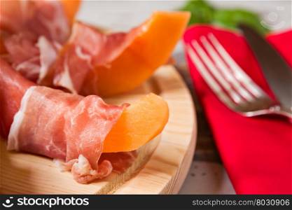 Close up of prosciutto and melon Italian appetizer on a cutting board. Close up of prosciutto and melon Italian appetizer