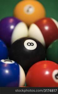 Close-up of rack of pool balls on green billiards table.