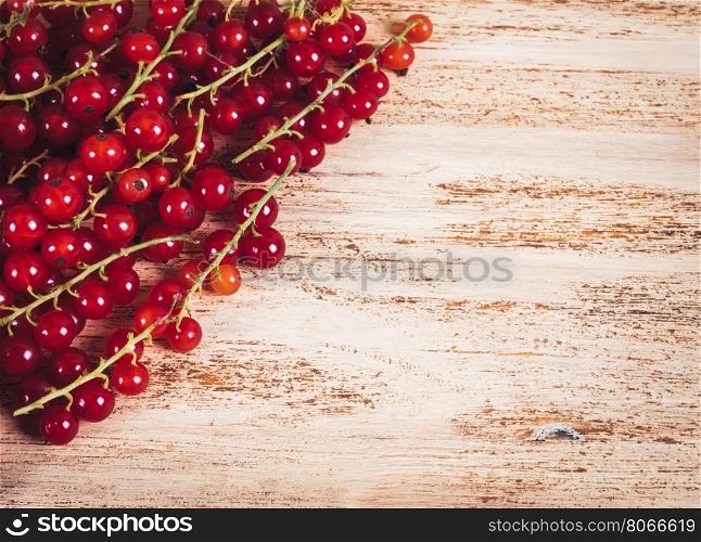 Close-up of red currants on a wooden background.. Berries of ripe red currant on wooden background