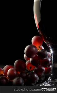 Close-up of red grapes and a glass of red wine