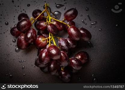 Close up of red grapes on black background with copy space. Water droplets, washing concept. Close up of red grapes on black background with copy space.