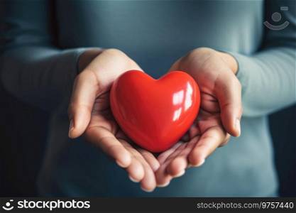 Close up of red heart holding in hands. Concept of health and medical care.