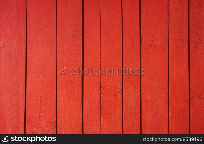 Close up of red painted wooden fence panels.