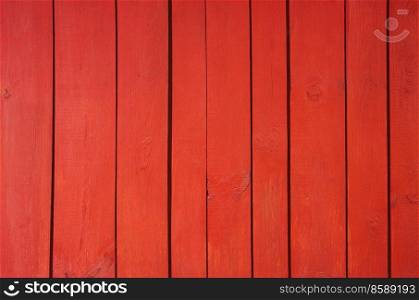Close up of red painted wooden fence panels.