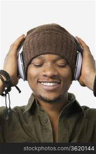 Close-up of relaxed young man listening music through headphones