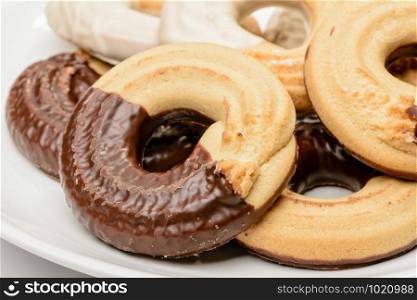 Close up of ring shaped chocolate biscuits in a porcelain plate isolated on white background