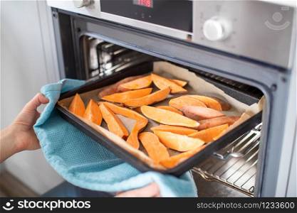 Close Up Of Roasting Tray Of Sweet Potato Wedges For Vegan Meal In Oven