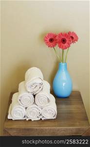 Close-up of rolled up towels with a flower vase