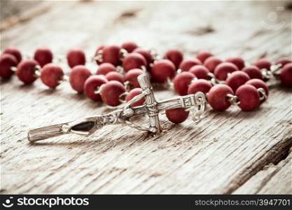 Close-up of rosary on old wooden texture background