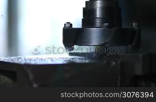 Close up of rotating head with drilling machine bits and tools processing of cutting metal at metalwork.