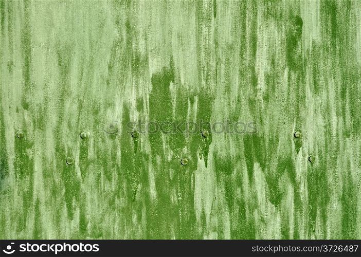 Close up of rough green colored metal background with bolts