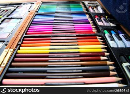 Close up of row of colored pencils and chalk in organizer case