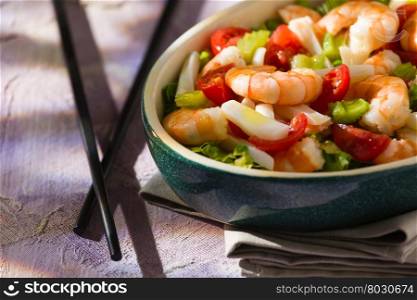 Close up of salad of shrimps and chopsticks inside an oval bowl. Close up of salad of shrimps and chopsticks