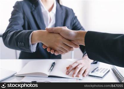 Close-up of salesman shaking hands with lovers who are customers In her office in the house purchase agreement Asian women and men smiling happily