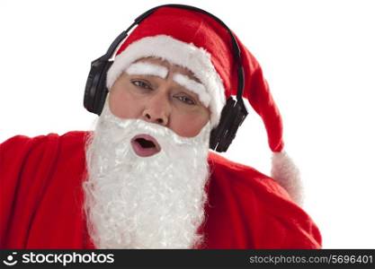 Close up of Santa Claus enjoying music over white background