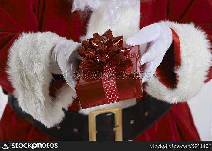 Close Up Of Santa Claus Holding Gift Wrapped Present