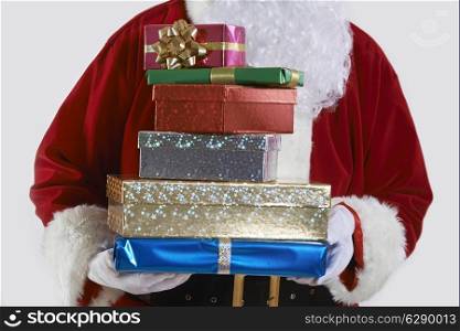 Close Up Of Santa Claus Holding Pile Of Gift Wrapped Presents
