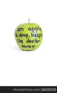 Close-up of sayings text on a juicy granny smith apple over white background