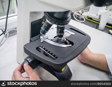 close-up of scientist hands with microscope, examining s&les and liquid