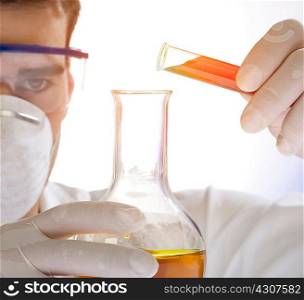 Close up of scientist pouring liquid from test tube