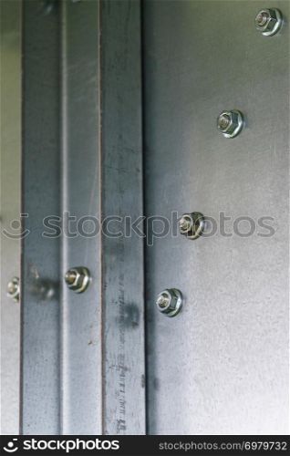 Close up of screw caps from screws on a metal steel wall. Industrial detaials concept.. Screw caps on a metal steel wall.