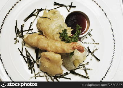 Close-up of seafood with a ketchup in a plate