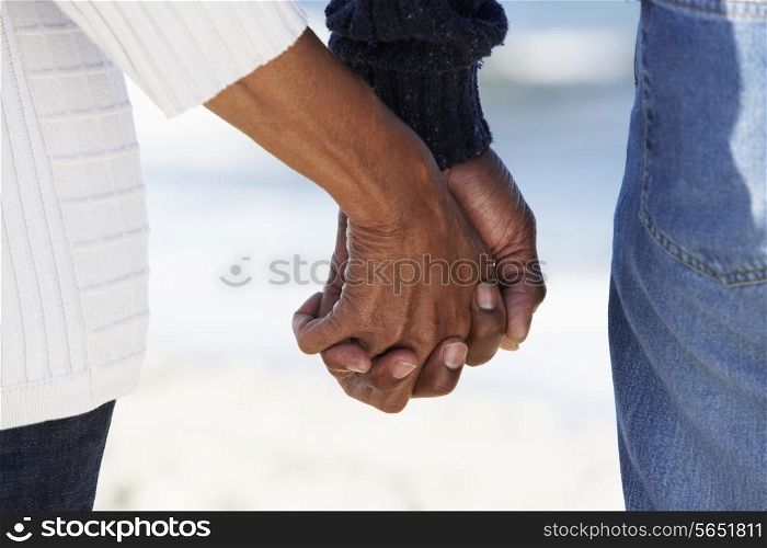 Close Up Of Senior Couple Holding Hands On Beach