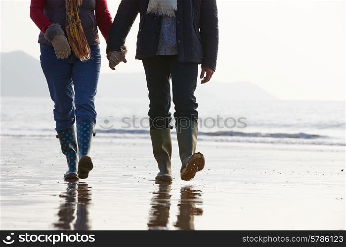 Close Up Of Senior Couple Walking Along Winter Beach
