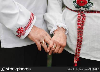 Close up of senior man and woman holding hands and walking outdoors. Rear view of old couple walking hand in hand outdoors. the old couple is holding hands. Close up of senior man and woman holding hands and walking outdoors. Rear view of old couple walking hand in hand outdoors. the old couple is holding hands.