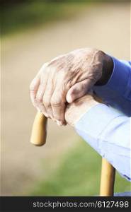 Close Up Of Senior Man&rsquo;s Hands Resting On Walking Stick